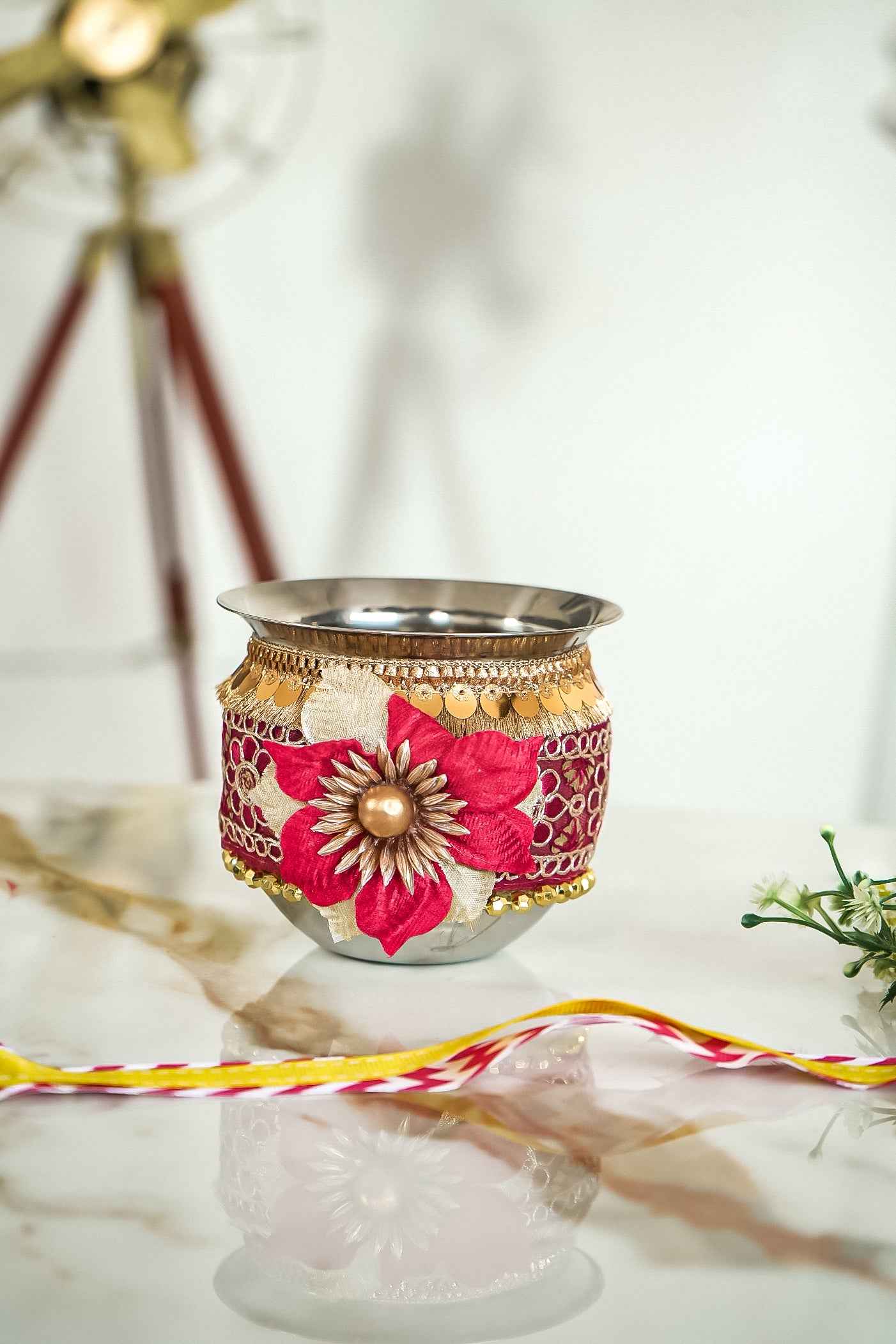 Decorative pot with floral design and gold accents on a white surface