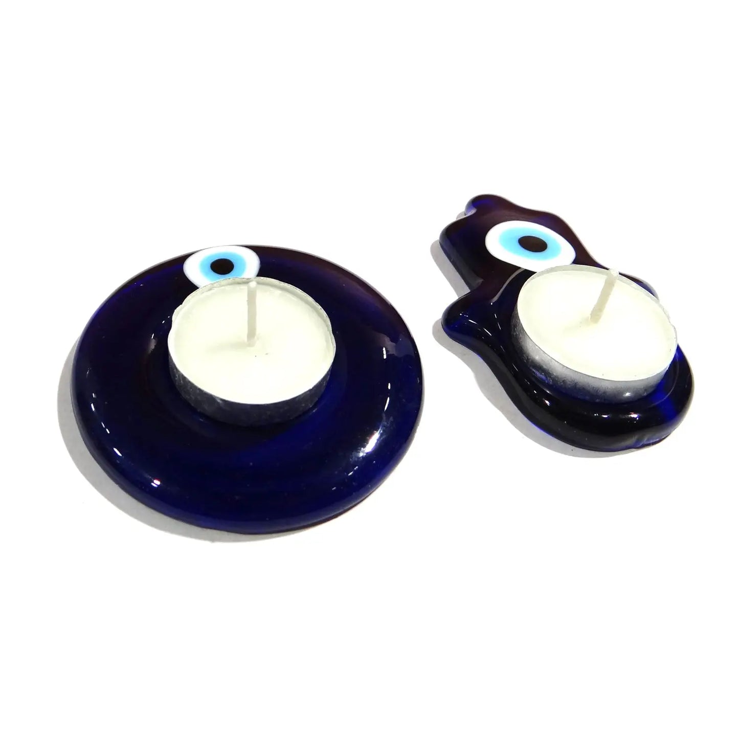 Two blue candle holders with white candles on a white background