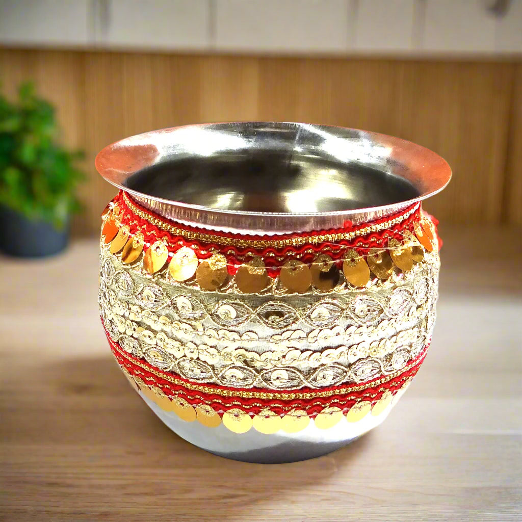 Decorative metal cup with red and gold patterns on a white background