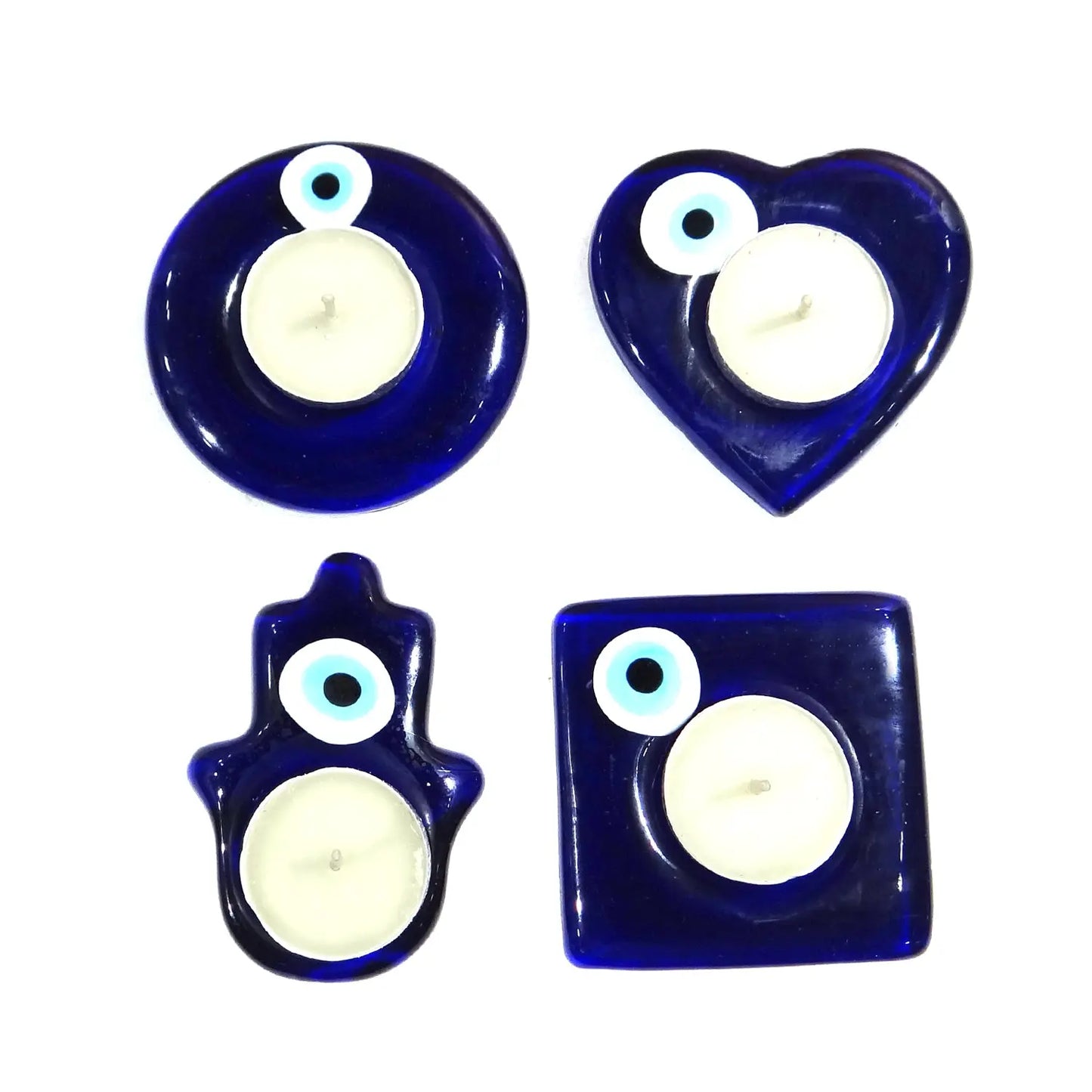 Set of four blue glass candle holders with white candles on a white background