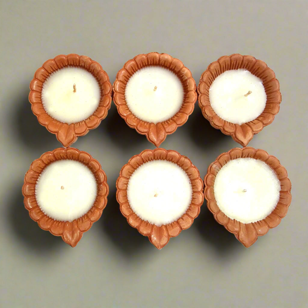Five white candles in brown candle holders arranged in a circular pattern on a white background.