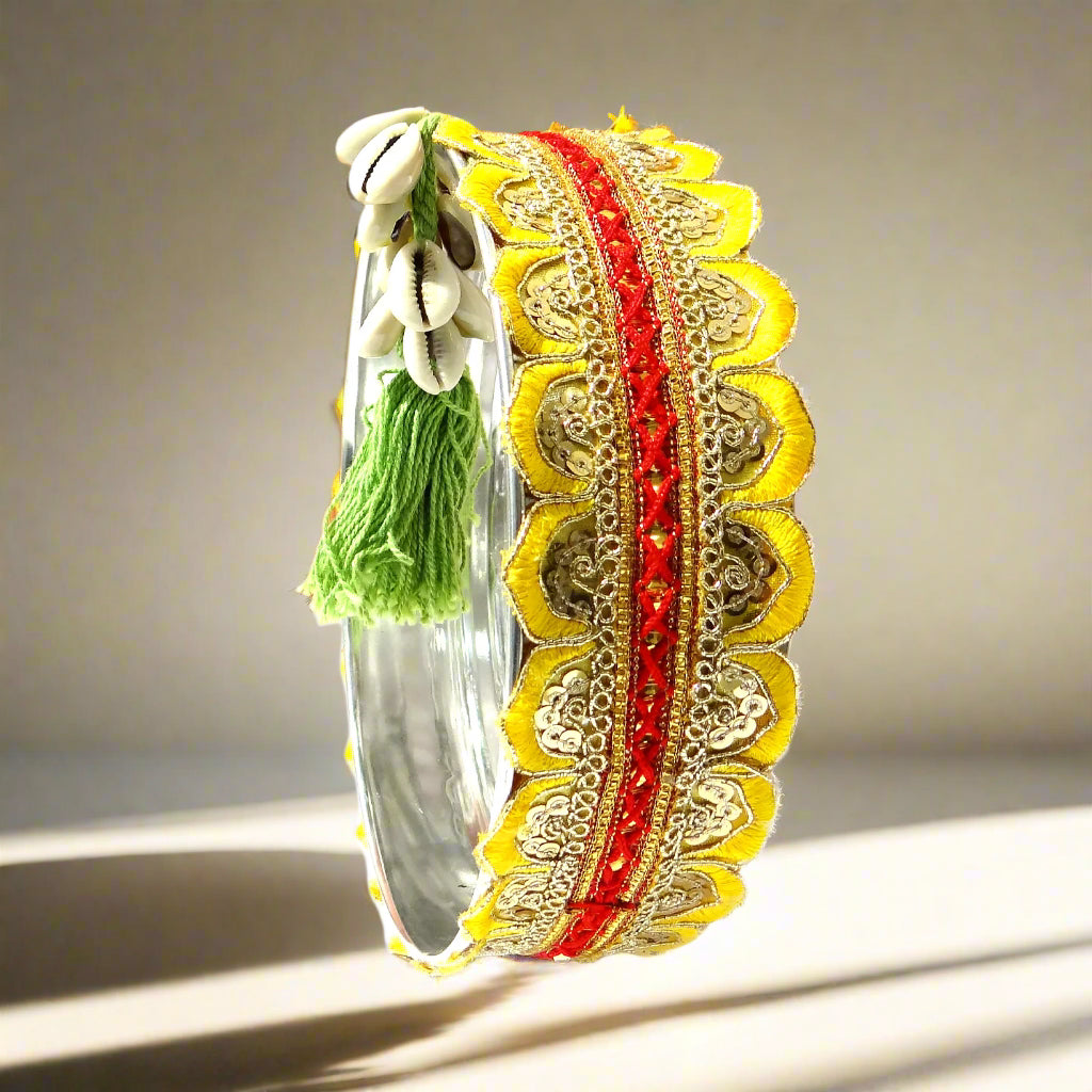 Decorative bangles with gold, red, and silver design on an orange background