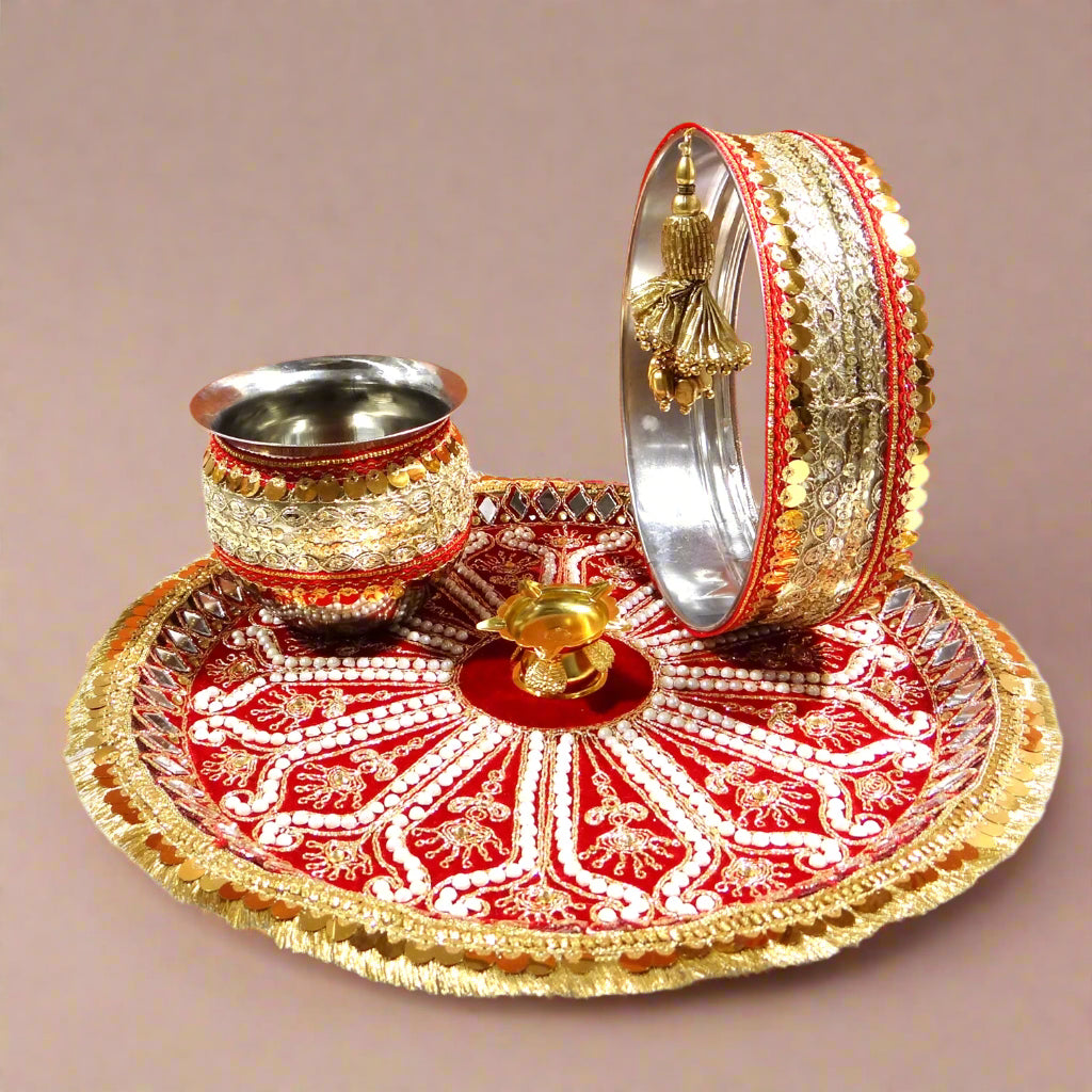 Decorative cup, plate, and bangles on a red and gold tray with an orange background