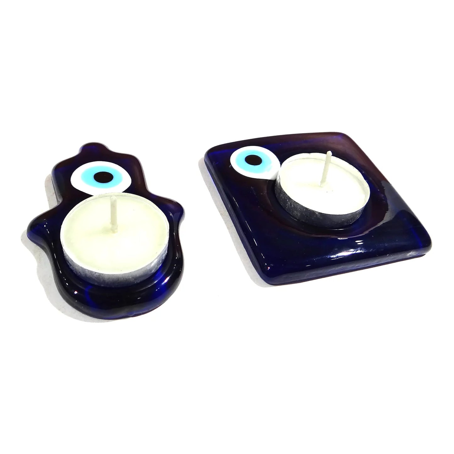 Two blue candle holders with evil eye design on a white background