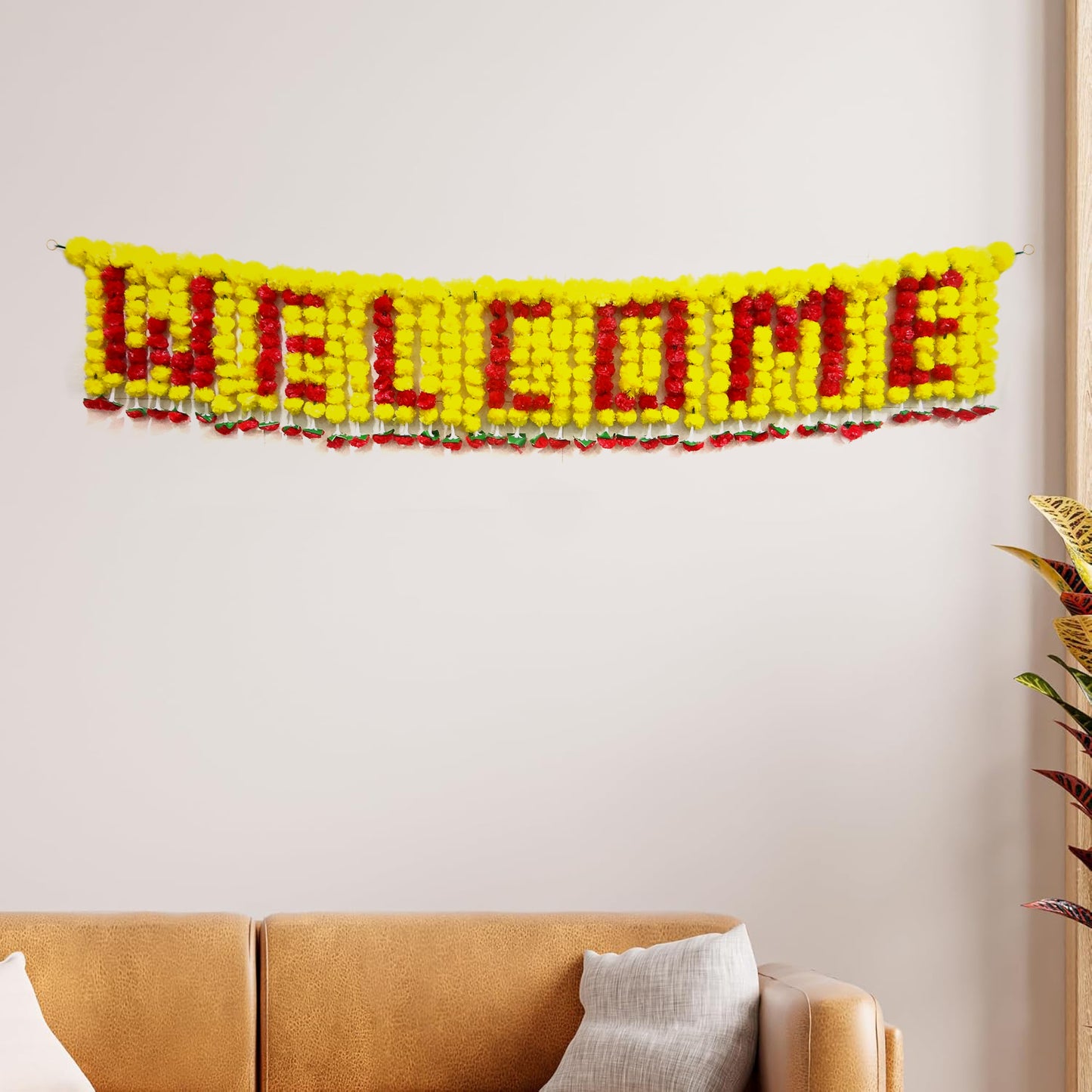 Decorative 'WELCOME' banner made of red and yellow yarn on a white wall above a brown sofa.