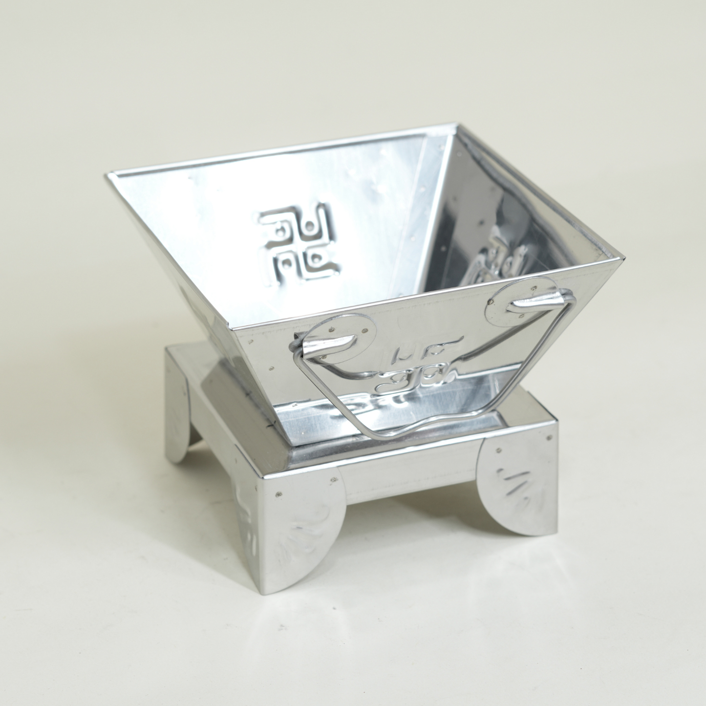 Metallic, reflective container on a light gray background