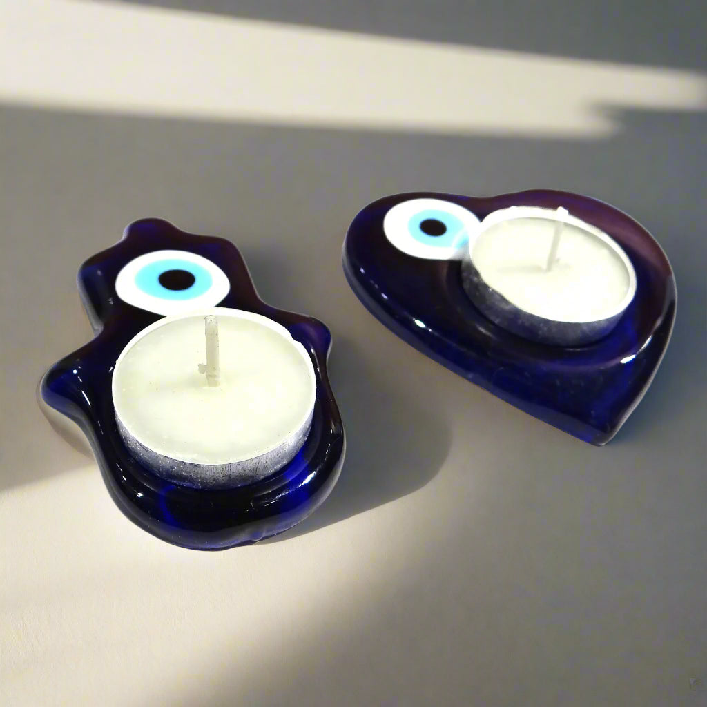 Two blue candle holders with white candles on a white background
