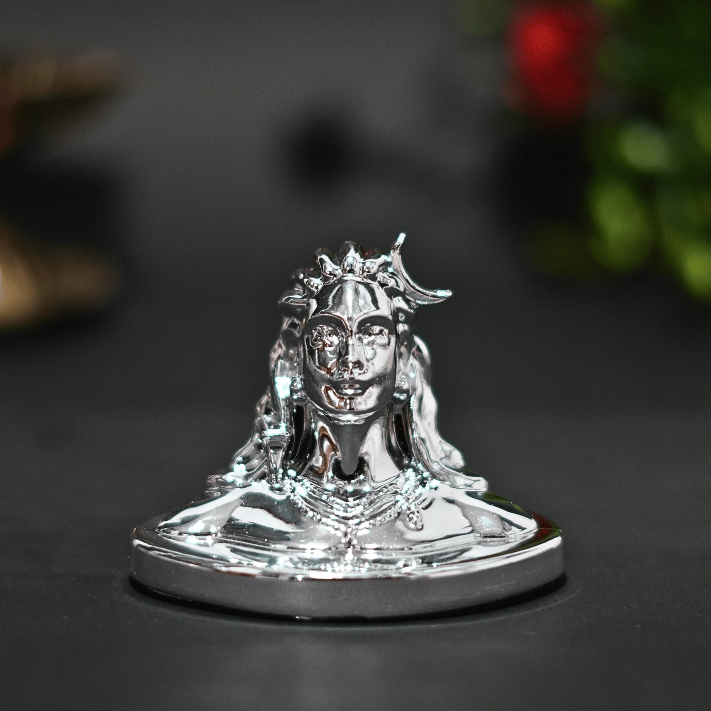 Silver statue of a deity on a dark background