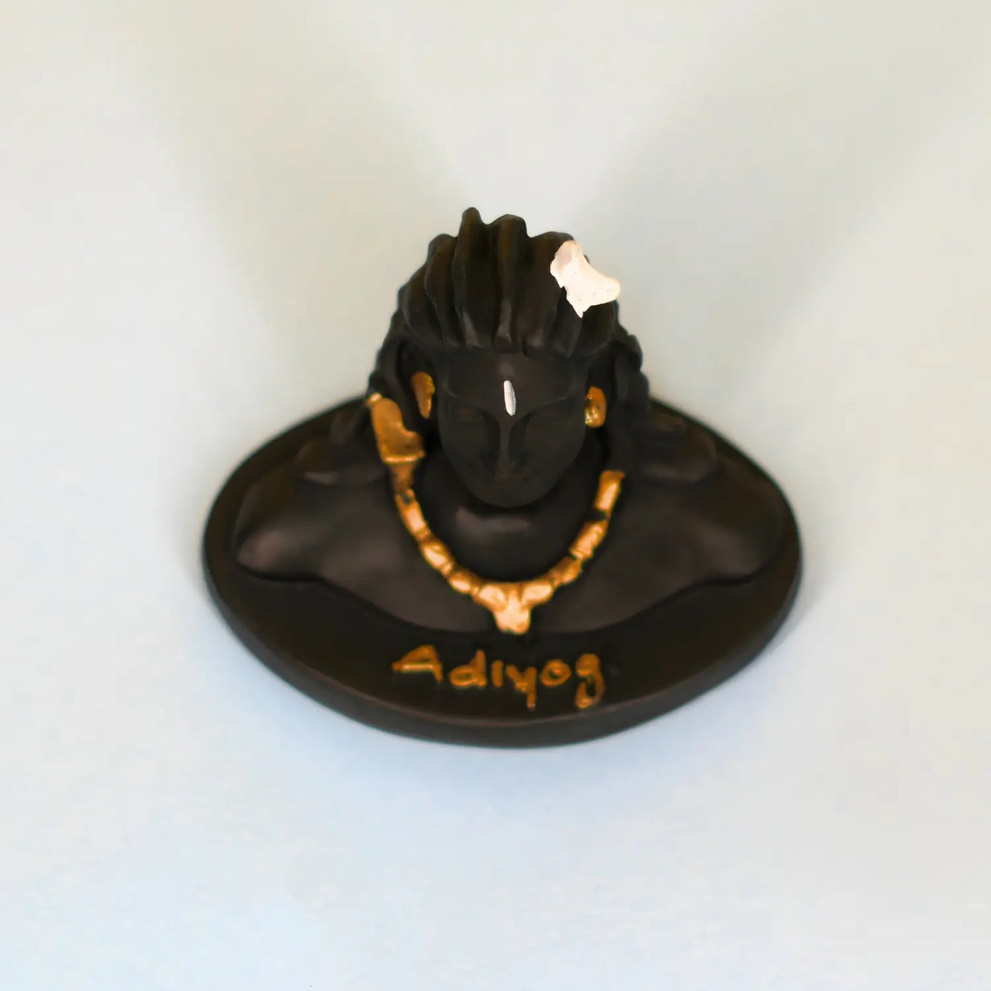 Black and gold figurine with 'Adiyog' text on a white background
