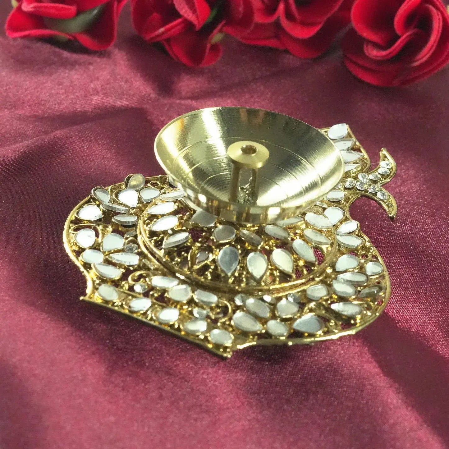 Decorative gold lamp with white stones on a red fabric background