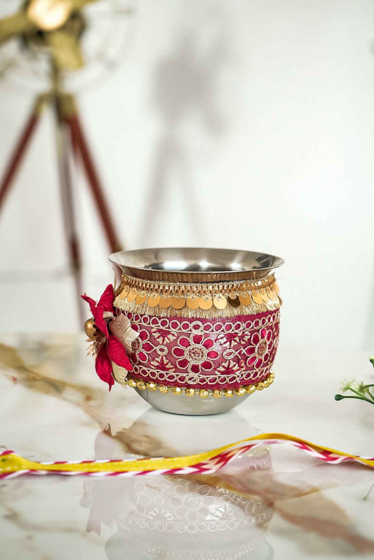 Decorative cup with floral patterns and a red flower on a marble surface