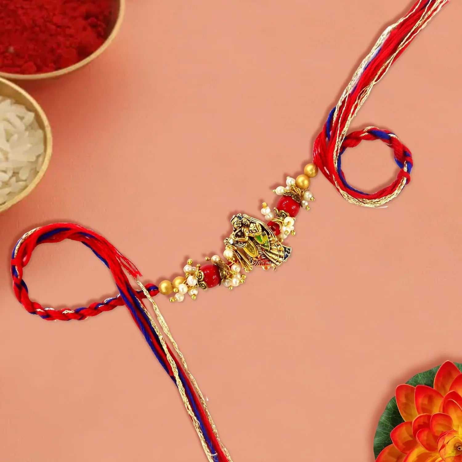 Decorative Rakhi with red and blue ribbons on a pink background