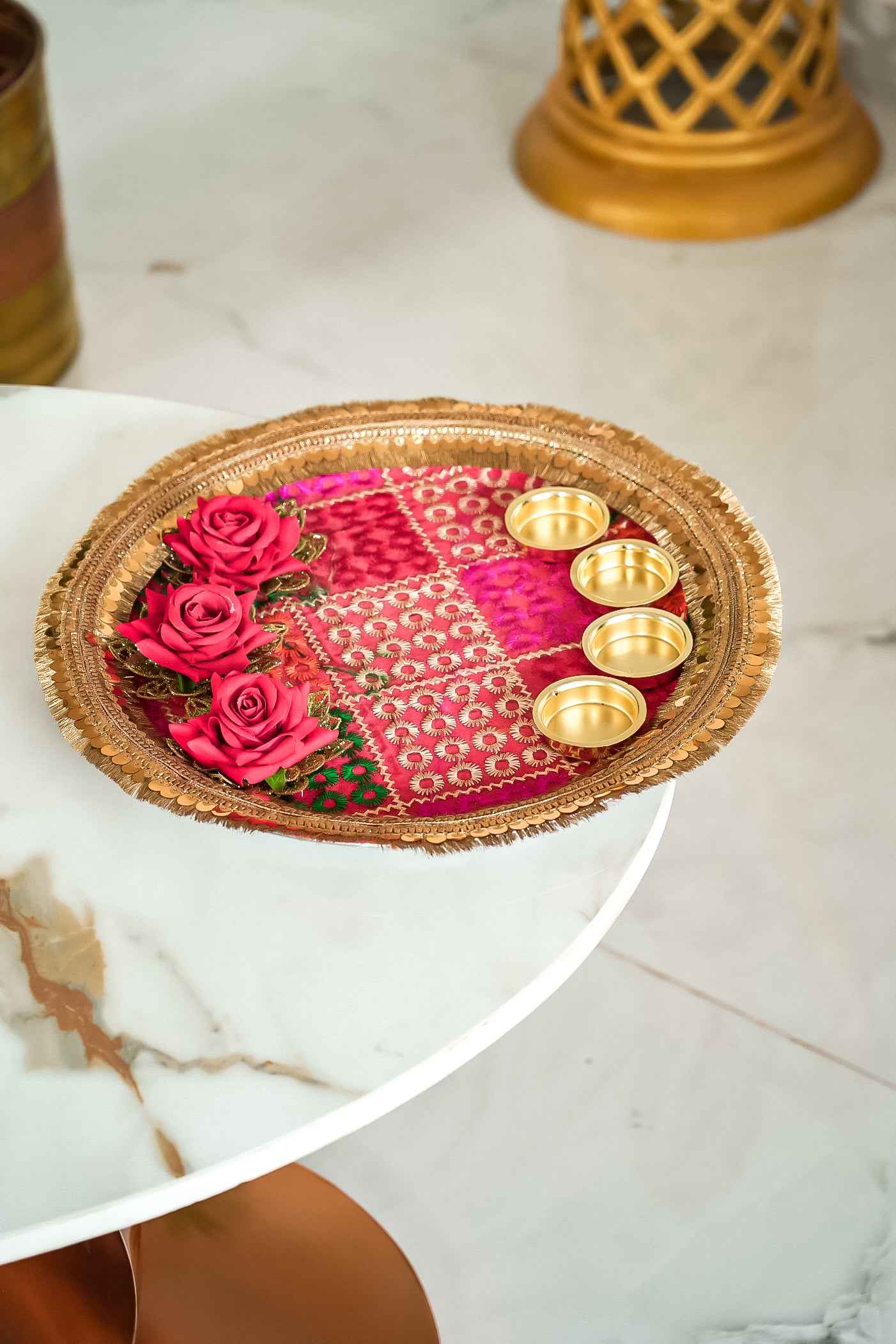 Decorative tray with pink flowers and gold elements on a marble surface