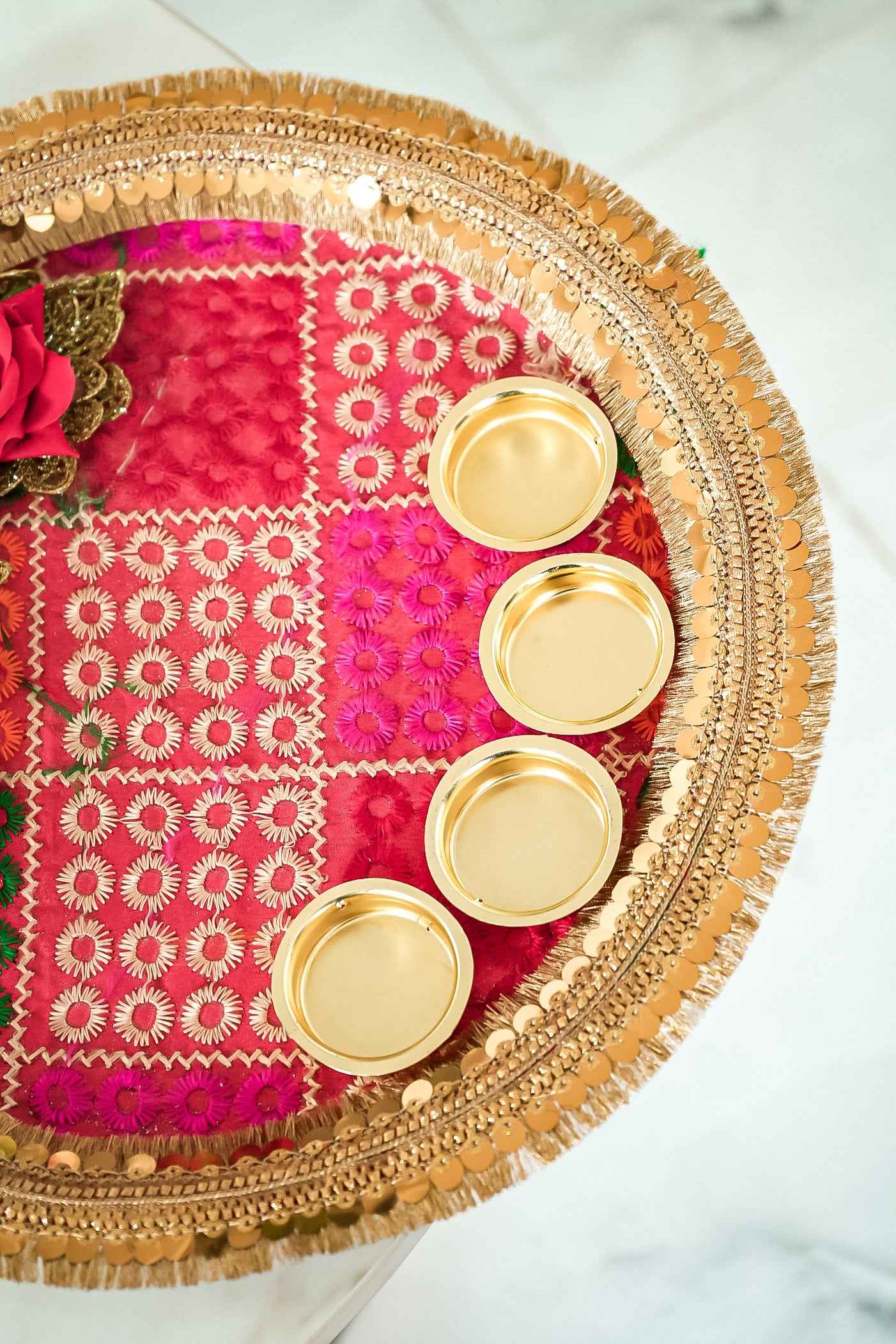 Decorative tray with gold coasters on a pink fabric background