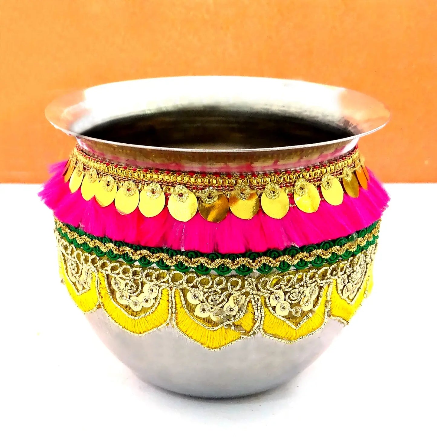 Decorative metal pot with colorful embellishments on a white background