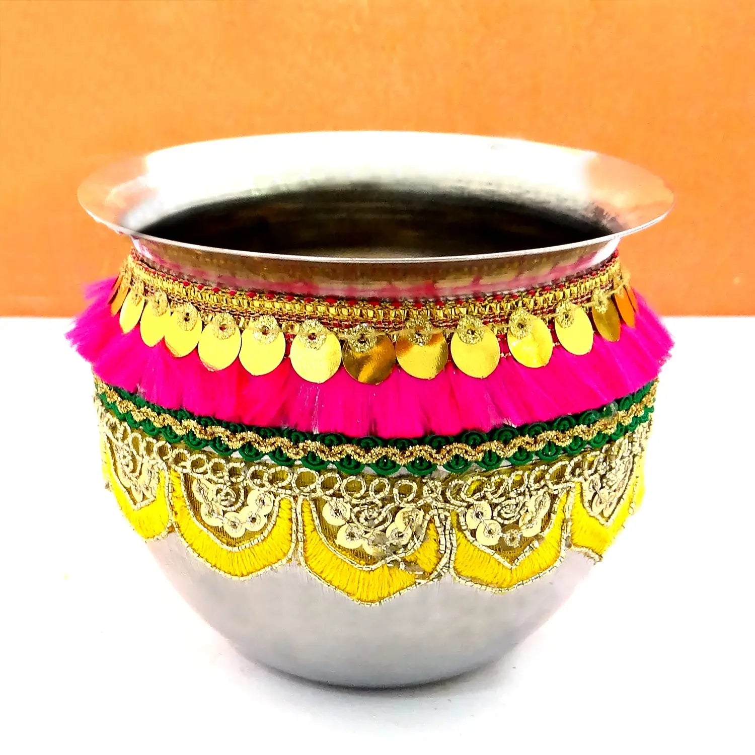 Decorative metal pot with colorful embellishments on a white background