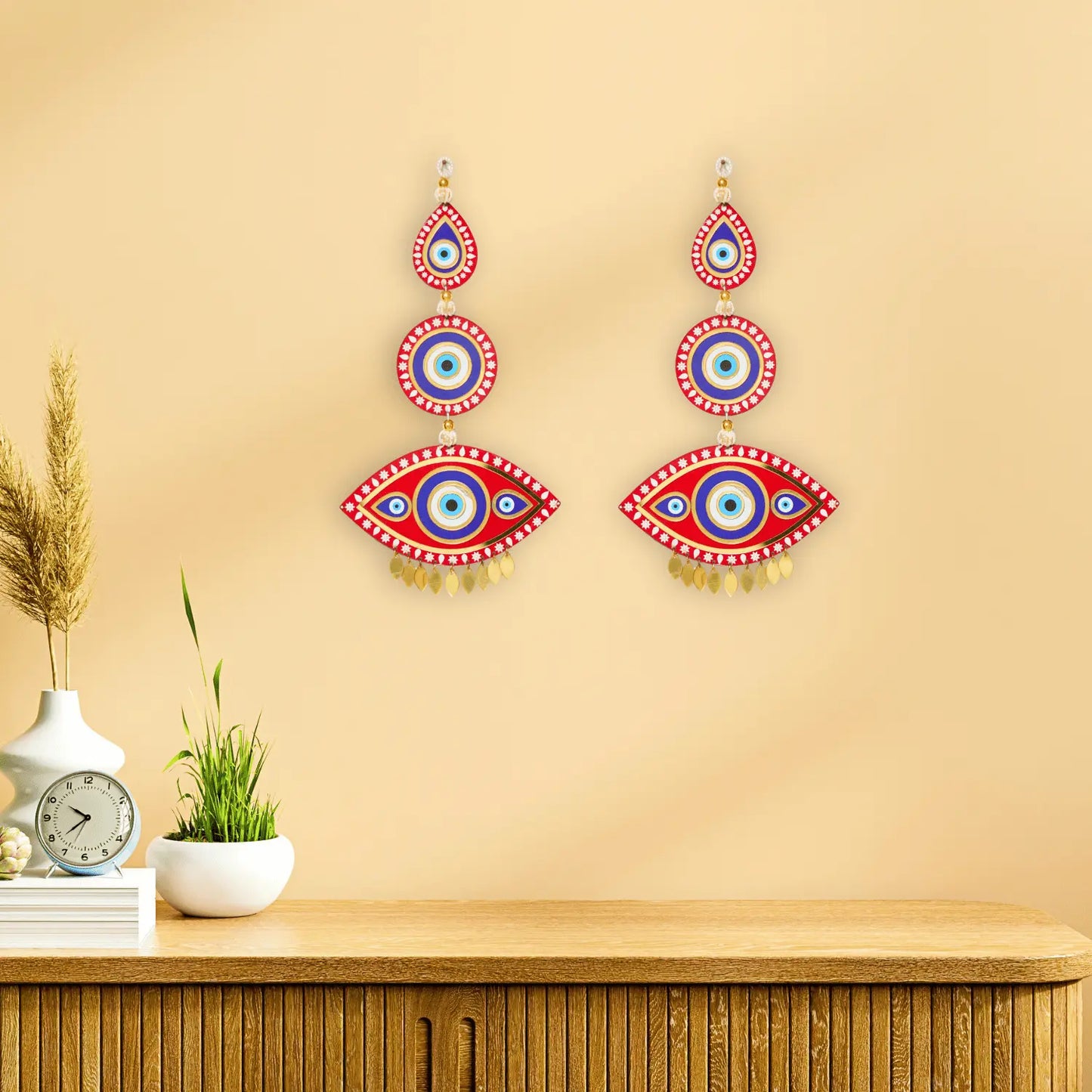 Decorative wall stickers resembling eyes on a beige wall above a wooden cabinet.