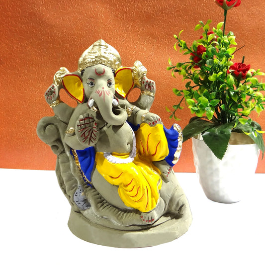 Colorful statue of a deity with a plant on an orange background