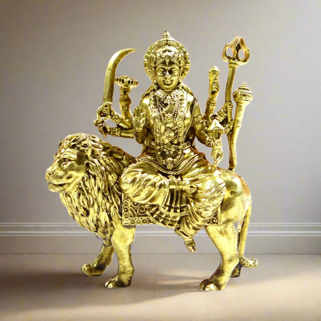 Gold-colored statue of a deity sitting on a lion