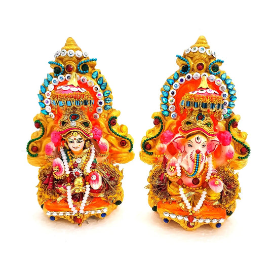 Decorative statues of a deity and a pink elephant with intricate details on a white background