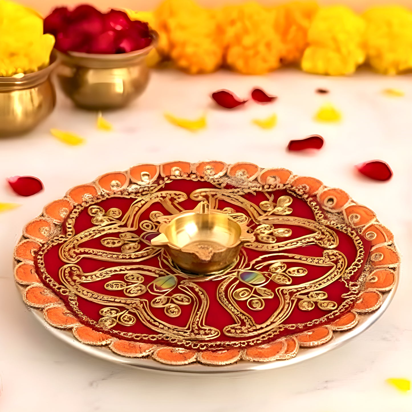 Decorative red and gold plate with a lit candle on a marble surface with candles and flowers.
