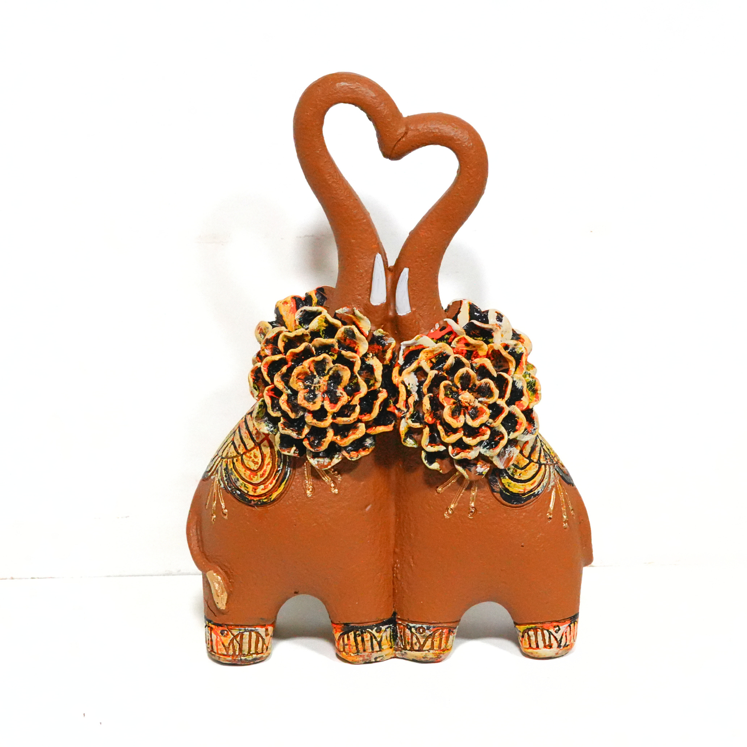 Decorative elephant with floral decorations and heart-shaped handles on a white background