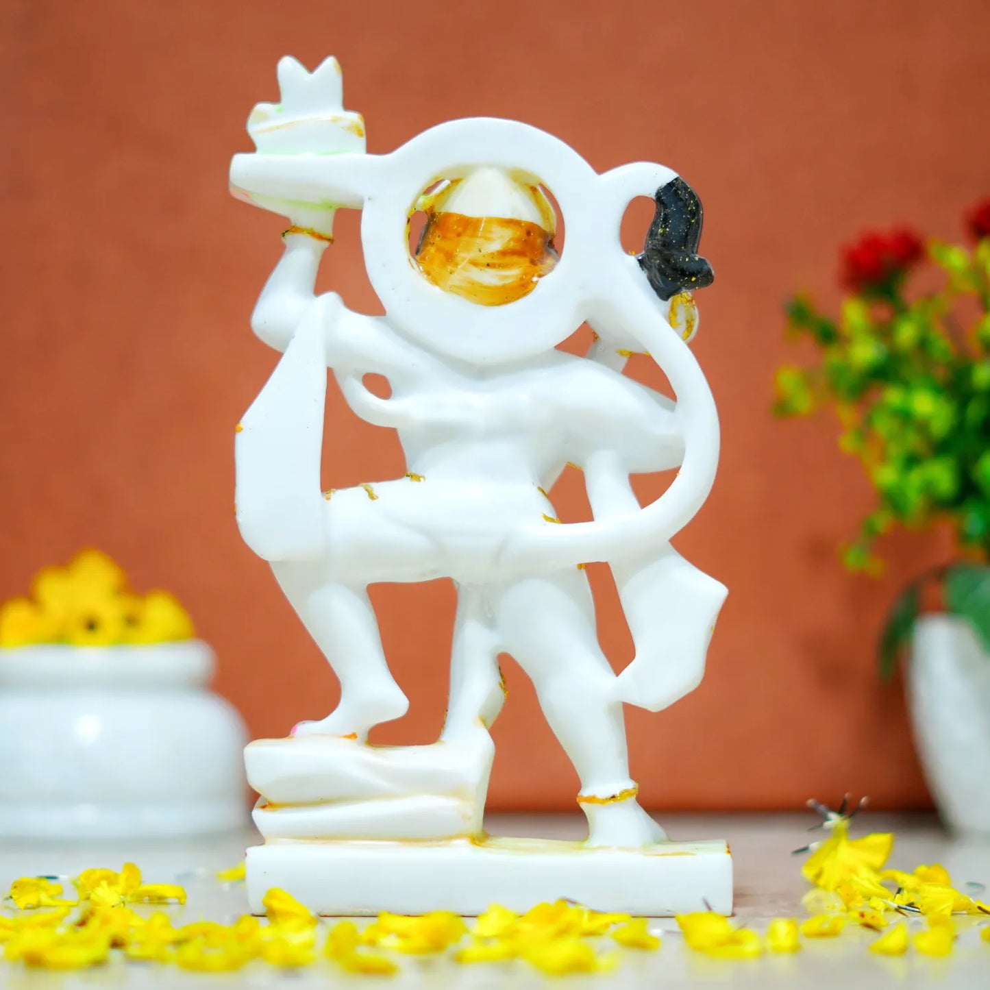 Decorative statue of a figure with a circular design on a brown background