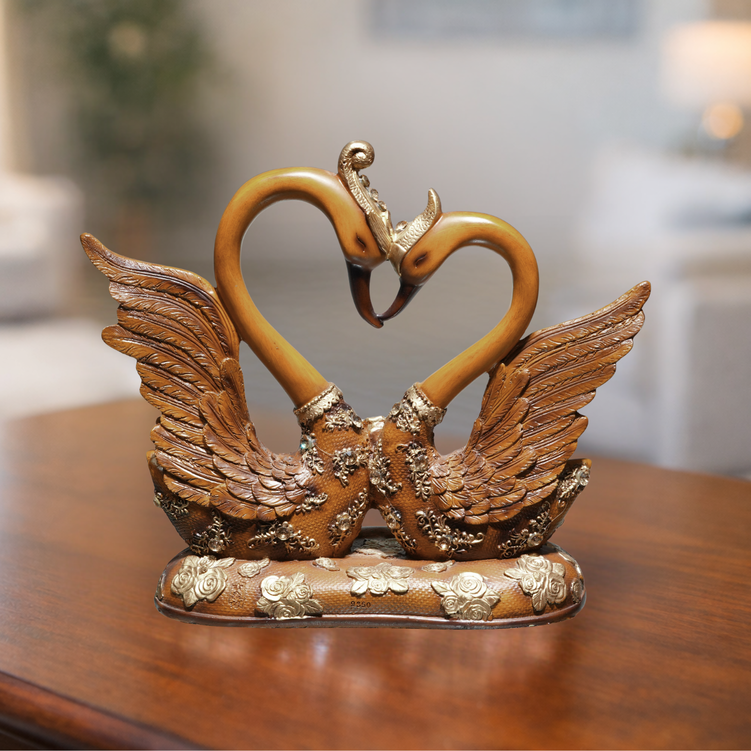 Decorative sculpture of two swans forming a heart shape on a wooden surface.