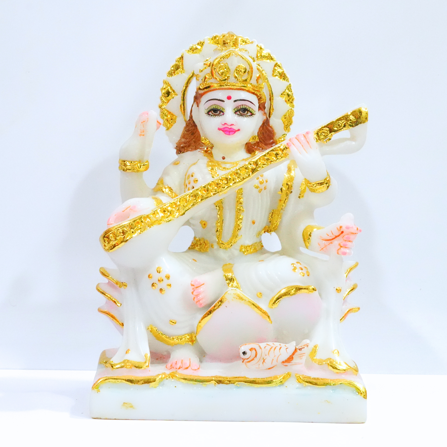 Decorative statue of a deity with gold and white colors on a light blue background