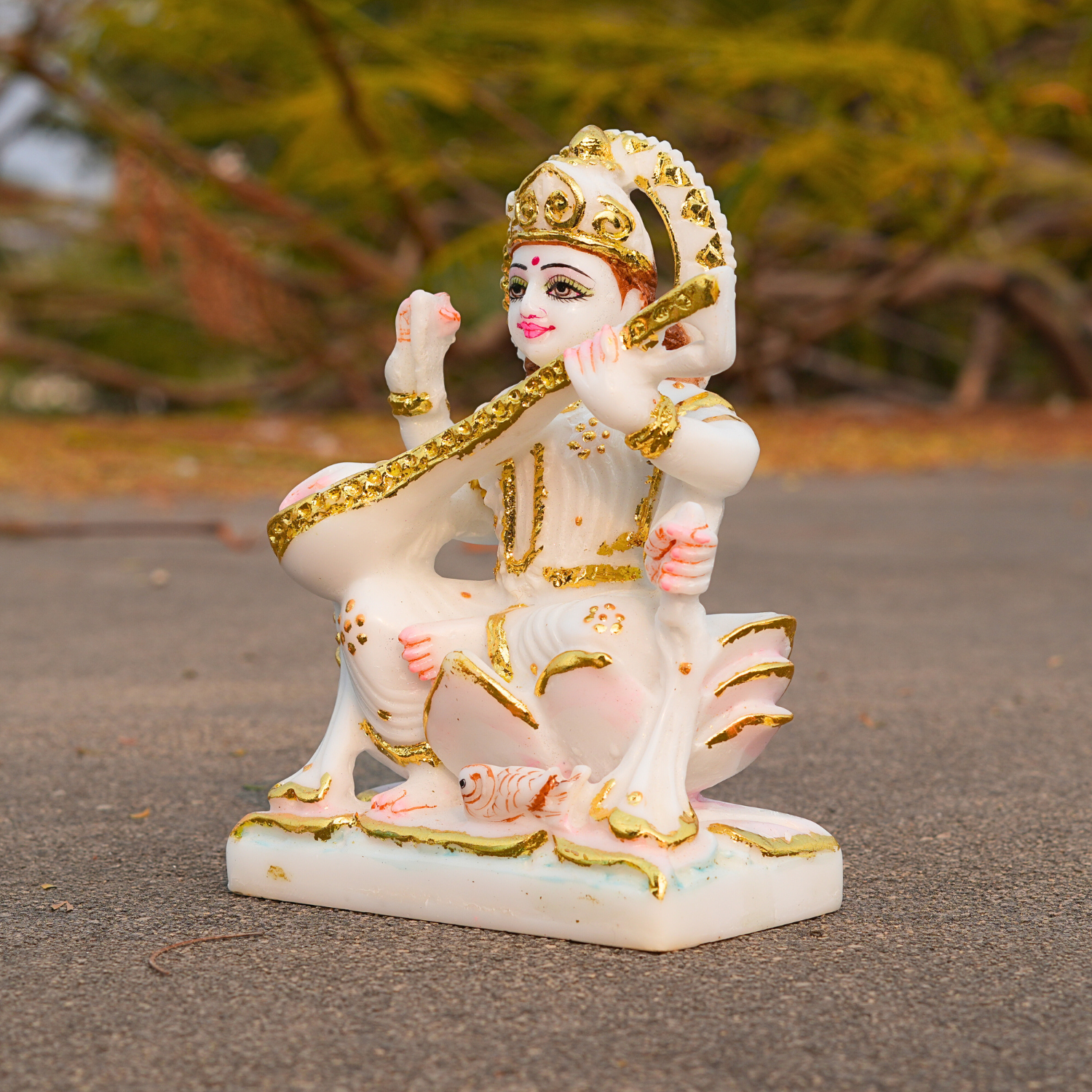 Decorative statue of a seated figure with gold accents on a textured surface