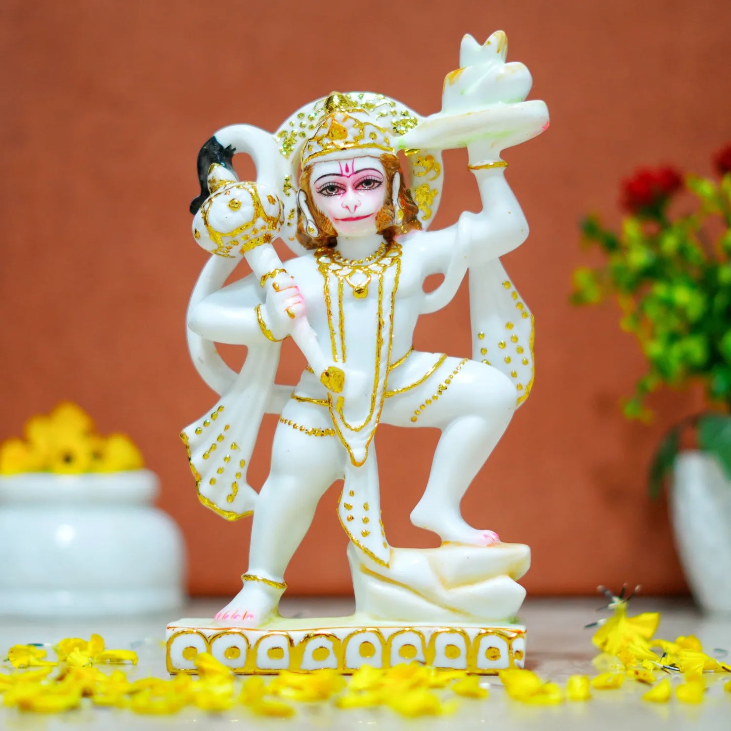 Decorative statue of a deity with gold accents on a brown background