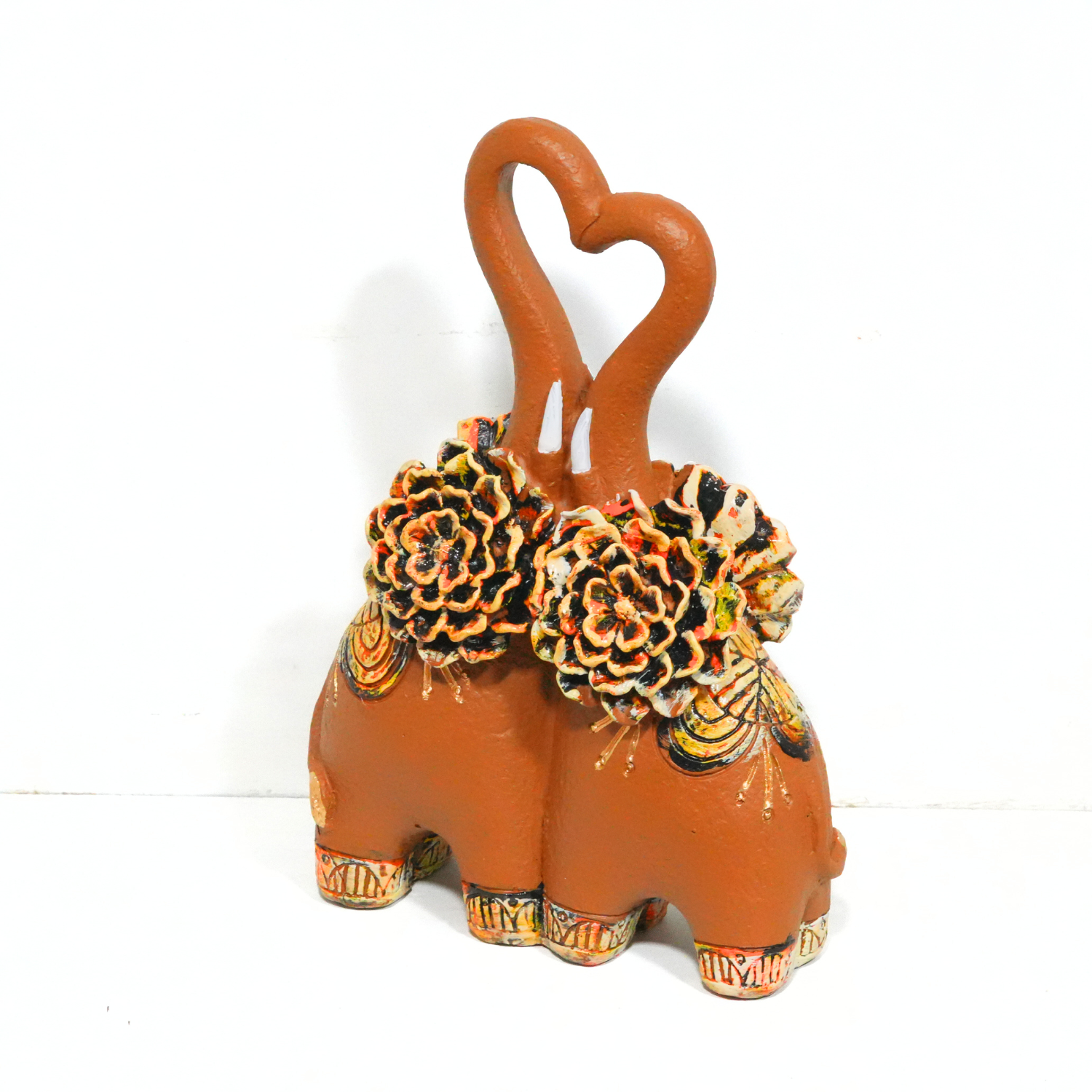 Decorative terracotta pot shaped like a elephant with heart handles on a white background