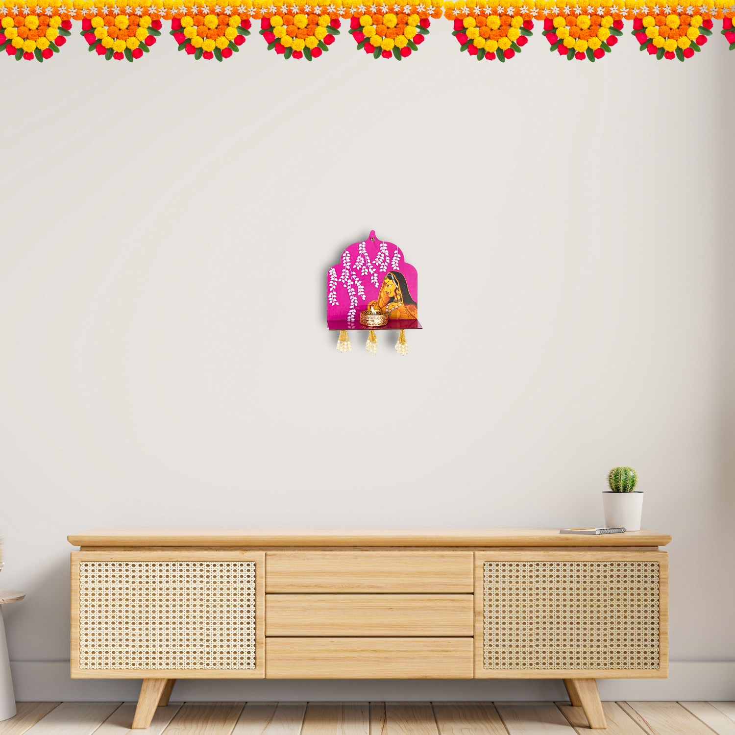 Decorative wall art on a white wall above a wooden cabinet with a plant.