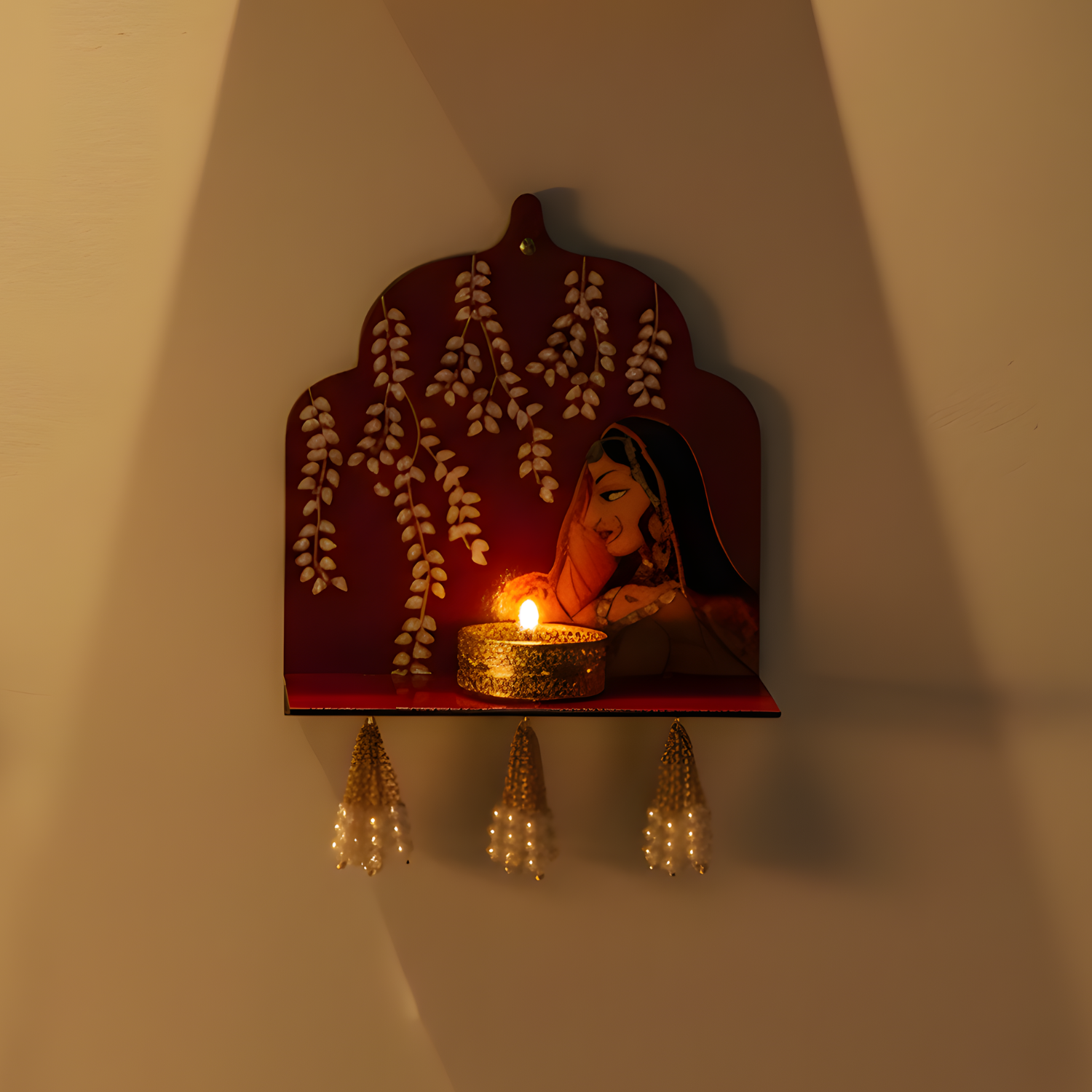 Decorative wall shelf with a lit candle and floral design on a plain wall.