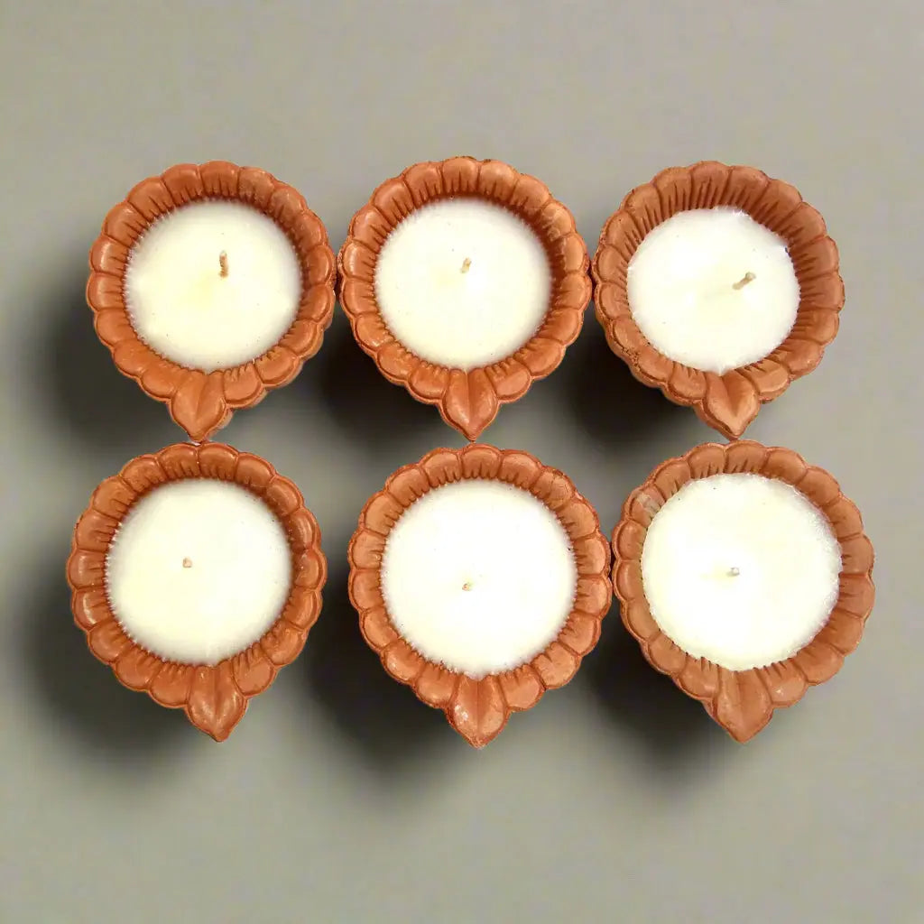 Five white candles in brown candle holders arranged in a circular pattern on a white background.