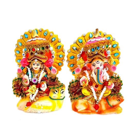 Decorative statues of a deity and a elephant-headed figure with colorful attire on a white background