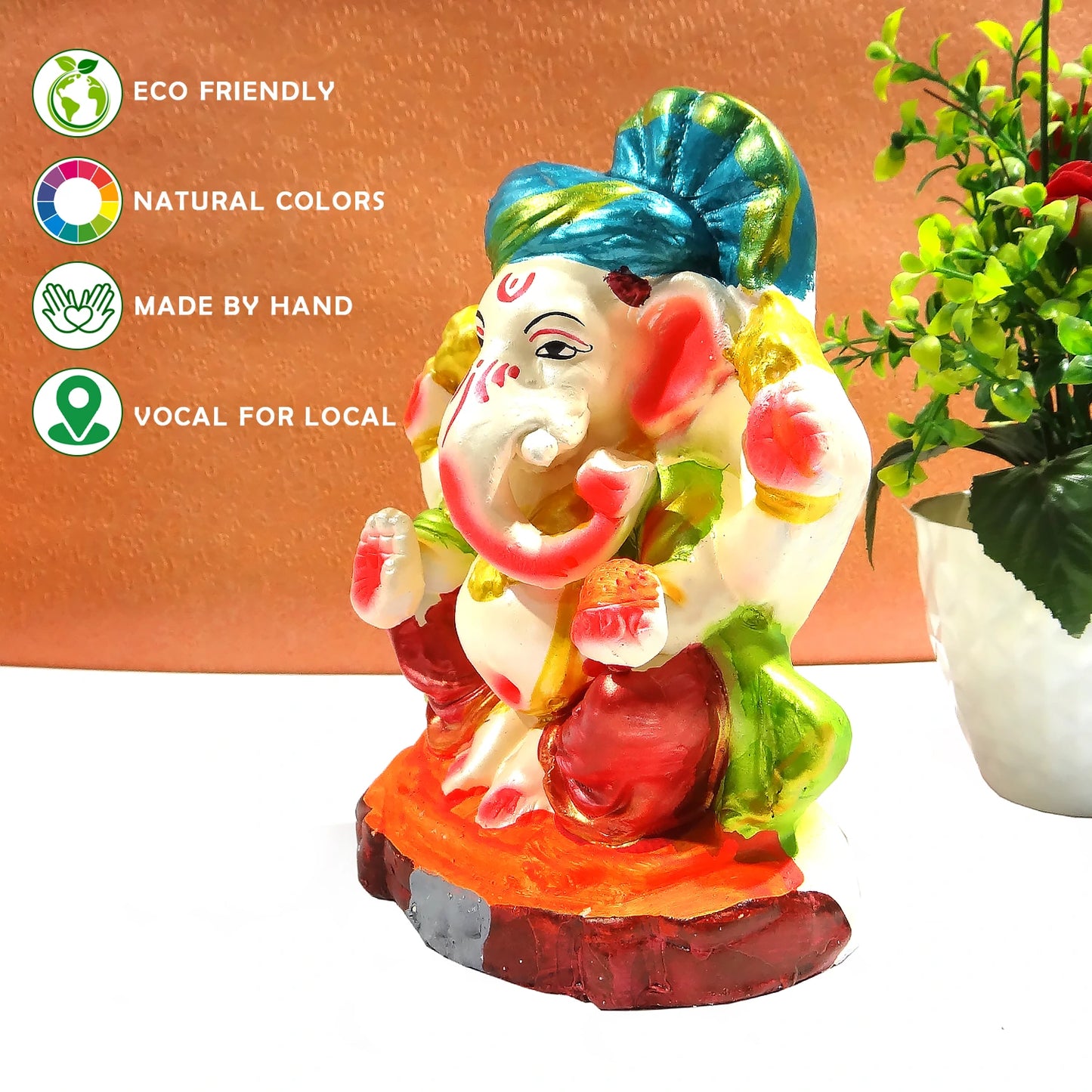 Colorful Ganesha statue with eco-friendly and handcrafted attributes on a white background