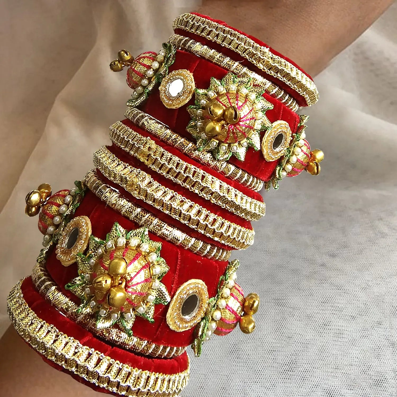 Decorative red and gold bangles on a neutral background
