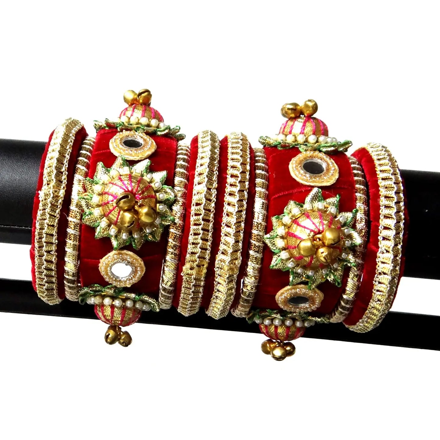 Decorative red and gold bangles on a black rod with a white background