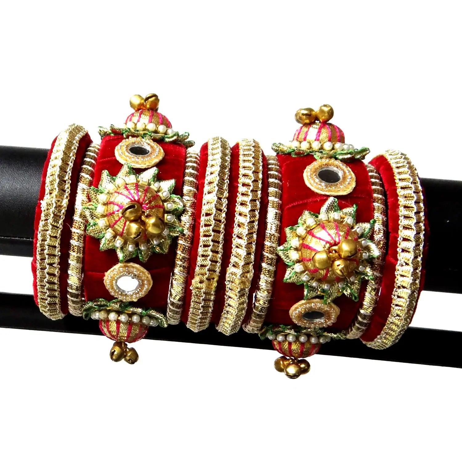 Decorative red and gold bangles on a black rod with a white background