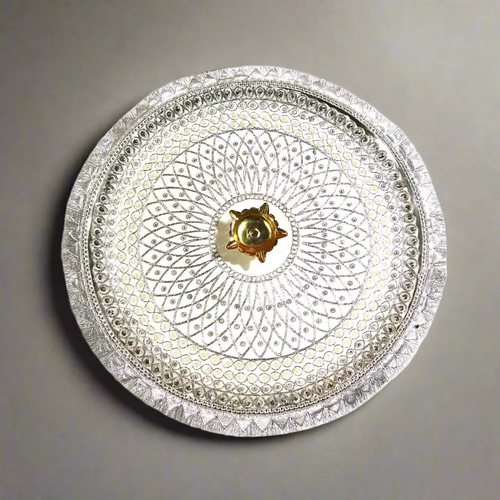 Decorative silver plate with intricate patterns on a white background