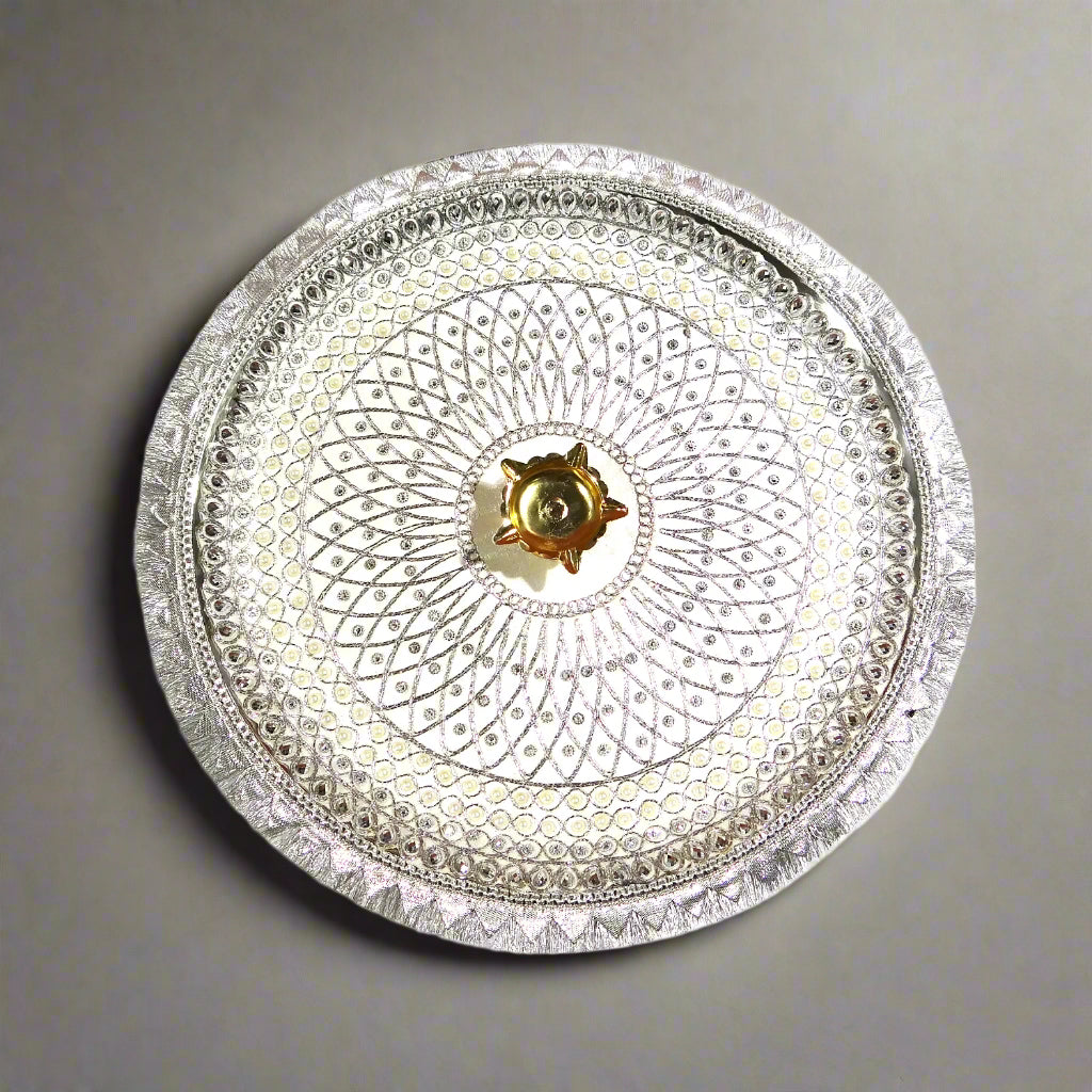 Decorative silver plate with intricate patterns on a white background