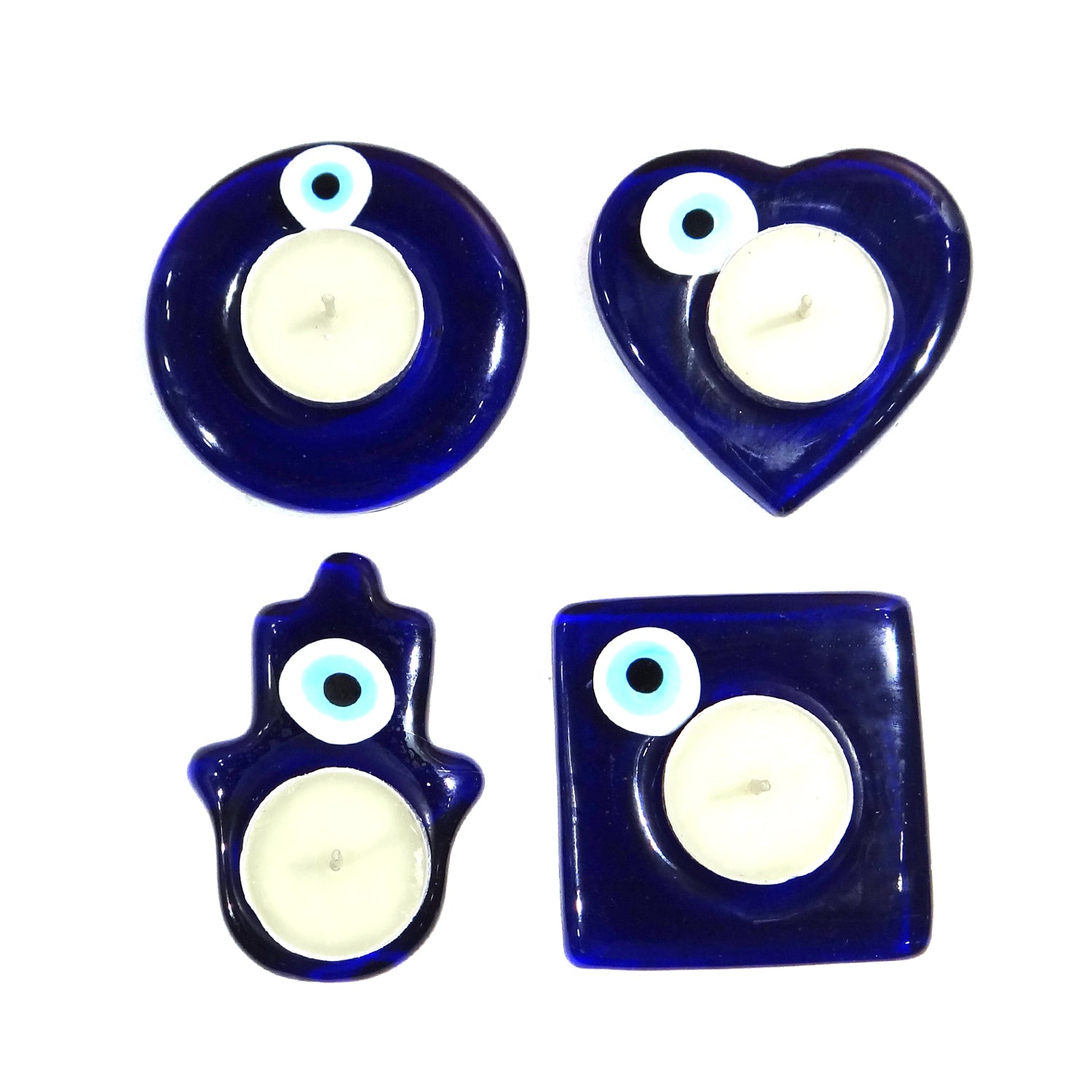 Set of four blue glass candle holders with white candles on a white background