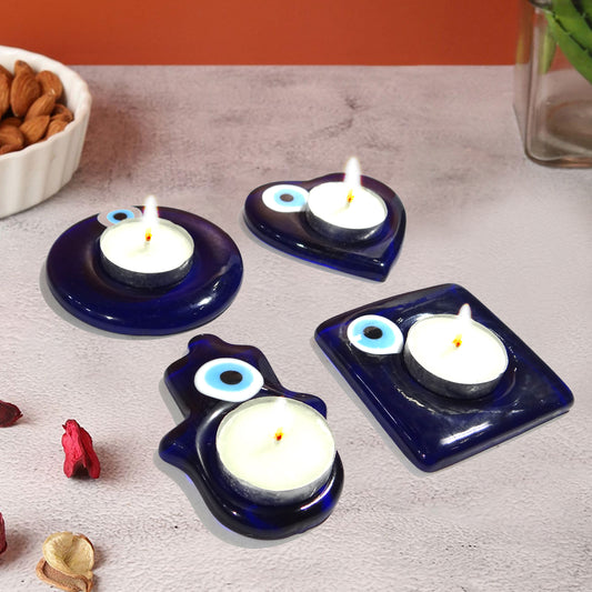 Set of four blue candle holders with candles on a gray surface.