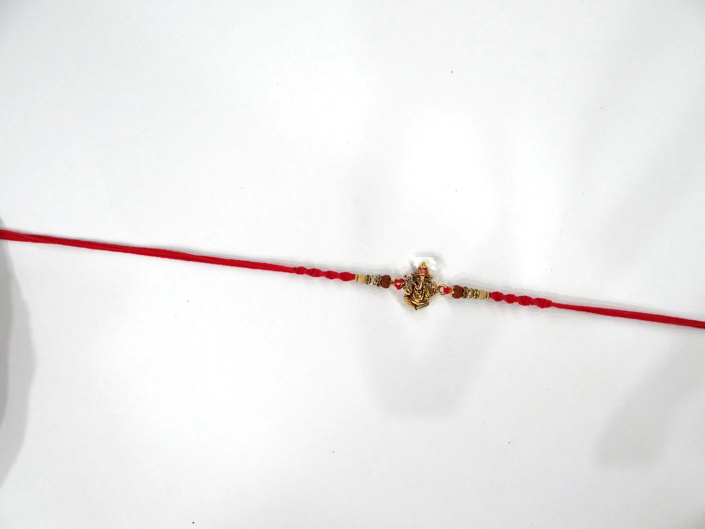 Red thread with a decorative clasp on a white background