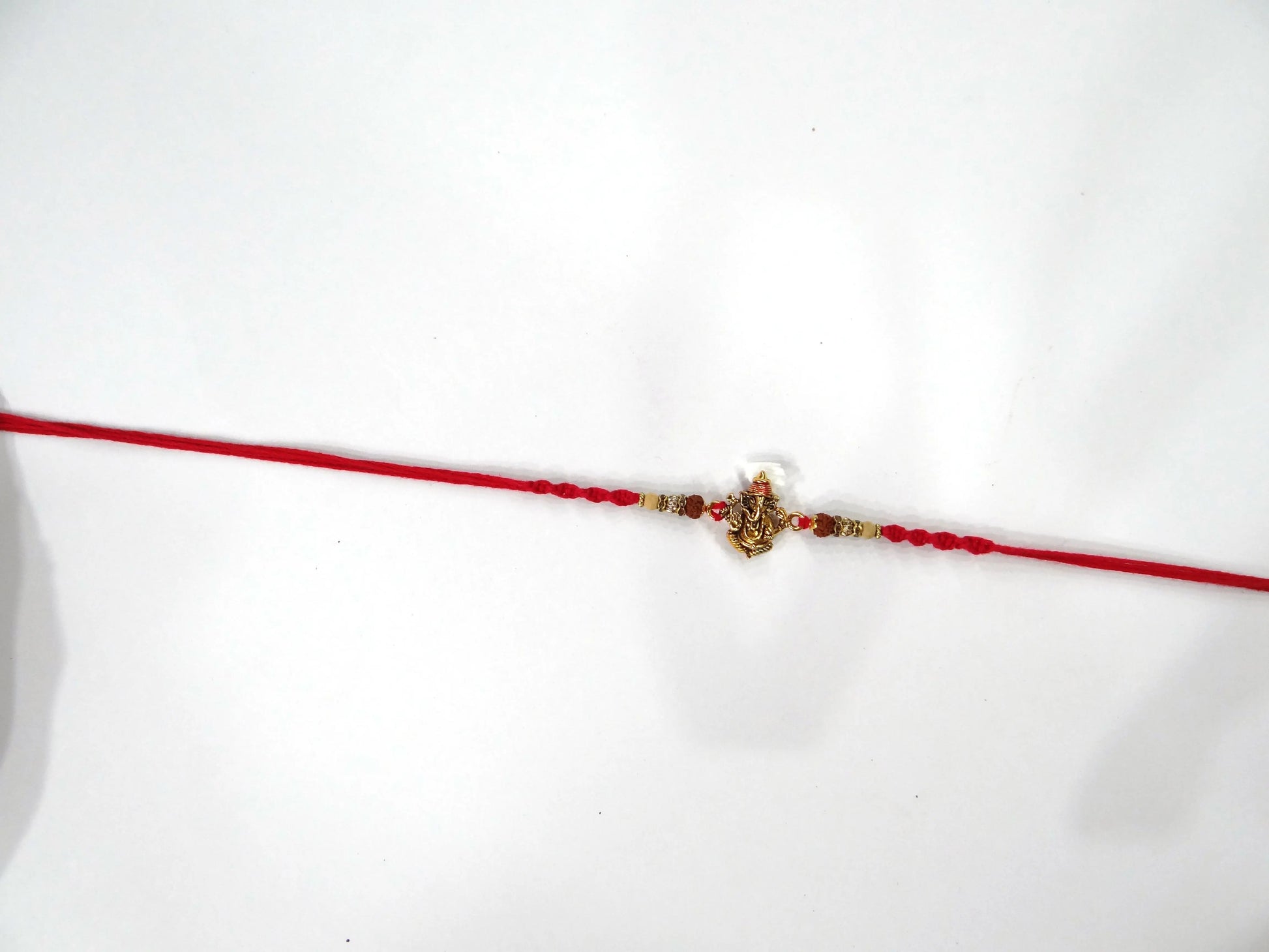 Red thread with a decorative clasp on a white background