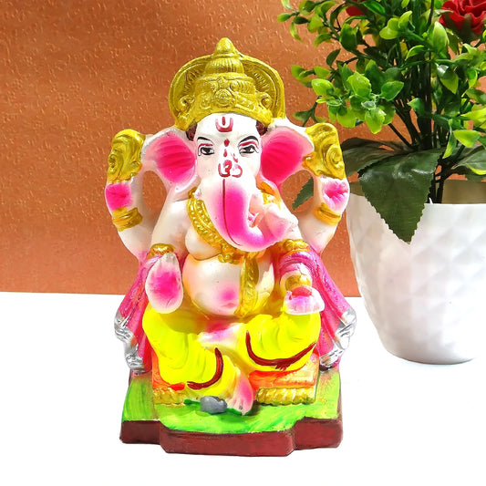 Colorful Ganesha statue with a plant in the background