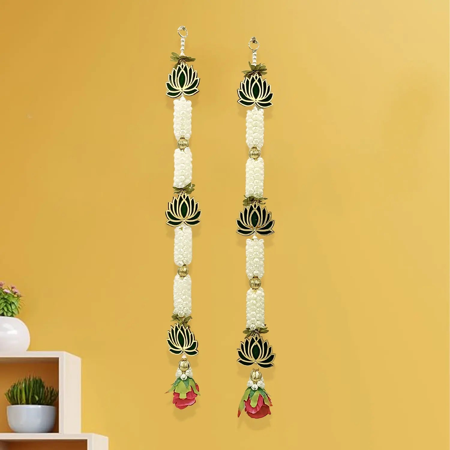 Long earrings with white beads and green leaves on a yellow background