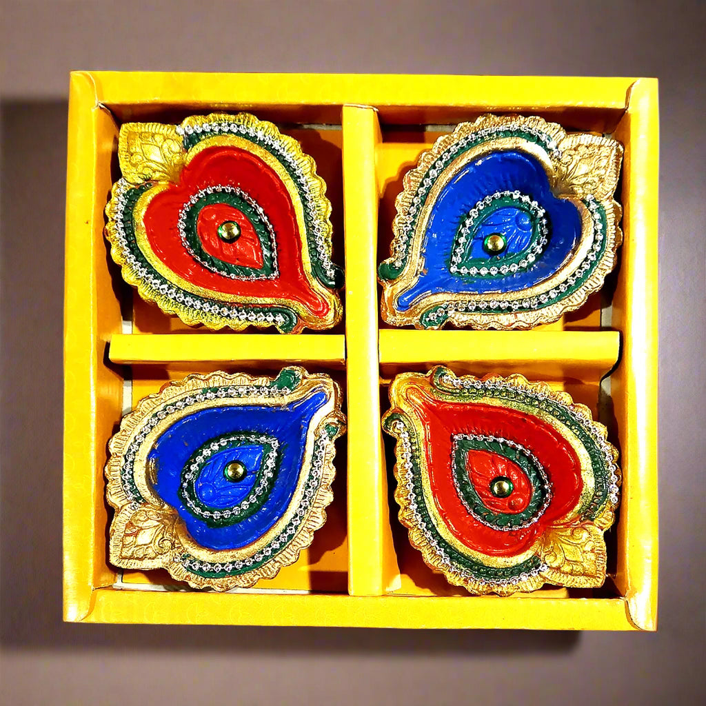Four colorful Diwali oil lamps in a yellow box