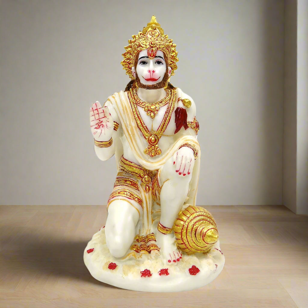 Statue of a monkey god with gold and red details on a neutral background